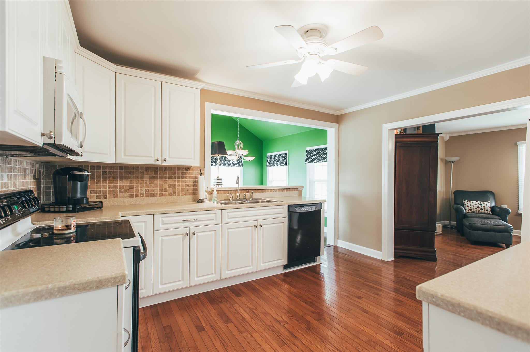 498 Canoe Branch Road Castalian Springs, TN 37031 - Photo 7 of 30 a kitchen with granite countertop a stove a sink a dining table and chairs with wooden floor
