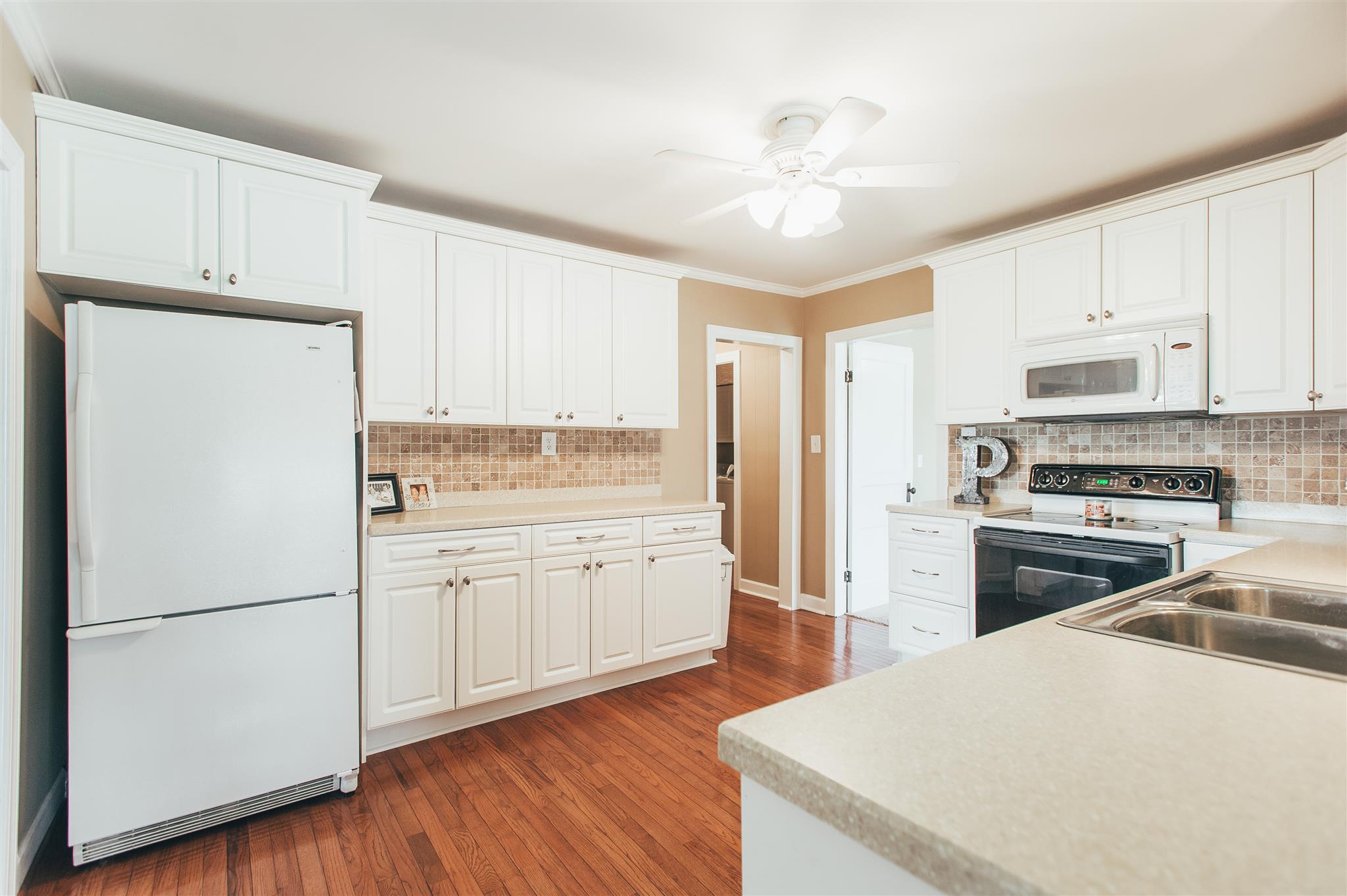 498 Canoe Branch Road Castalian Springs, TN 37031 - Photo 8 of 30 a kitchen with a refrigerator a stove cabinets and wooden floor