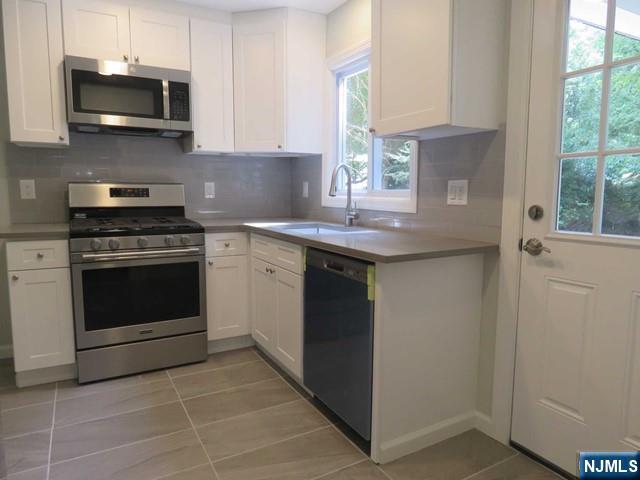 289 Hardenburgh Avenue Demarest, NJ 07627 - Photo 12 of 43 a kitchen with stainless steel appliances granite countertop a stove a sink and a microwave