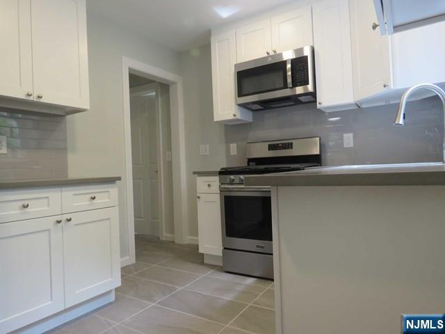 289 Hardenburgh Avenue Demarest, NJ 07627 - Photo 13 of 43 a kitchen with granite countertop a stove and a microwave