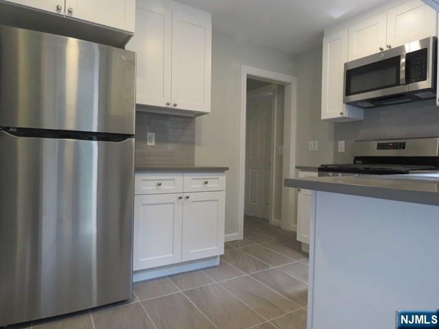 289 Hardenburgh Avenue Demarest, NJ 07627 - Photo 14 of 43 a kitchen with stainless steel appliances granite countertop a refrigerator and a stove top oven