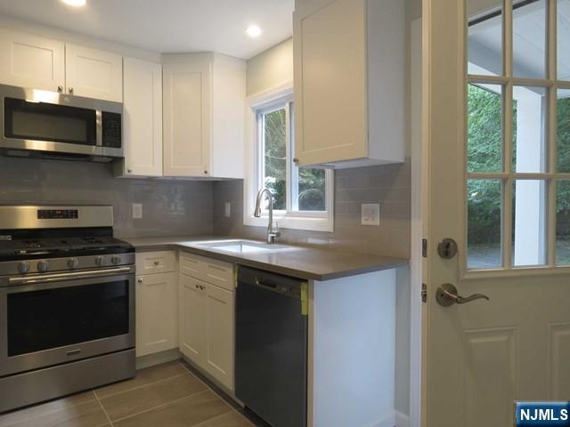 289 Hardenburgh Avenue Demarest, NJ 07627 - Photo 15 of 43 a kitchen with a sink stove and microwave