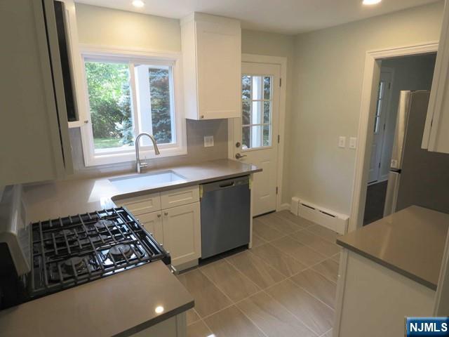 289 Hardenburgh Avenue Demarest, NJ 07627 - Photo 17 of 43 a kitchen with a sink a stove cabinets and a window