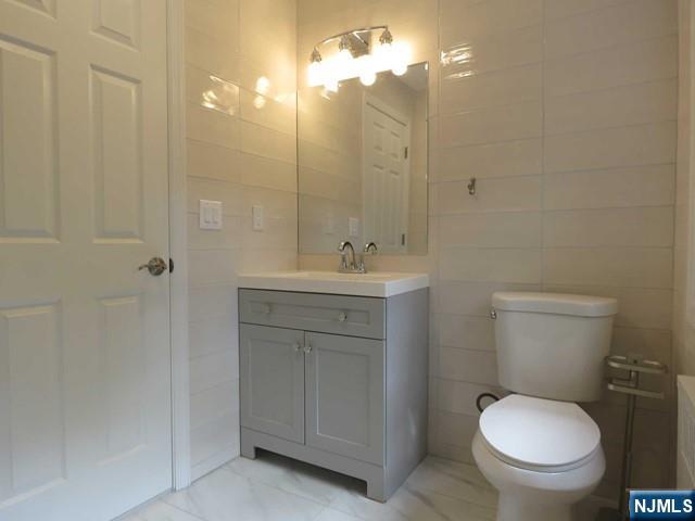 289 Hardenburgh Avenue Demarest, NJ 07627 - Photo 34 of 43 a bathroom with a toilet sink vanity and mirror