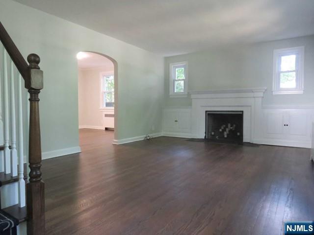 289 Hardenburgh Avenue Demarest, NJ 07627 - Photo 5 of 43 an empty room with wooden floor a fireplace and windows