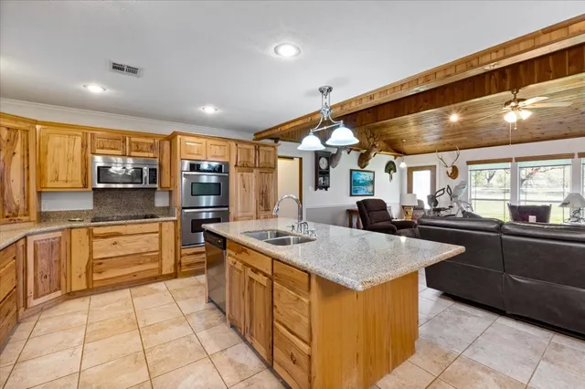 a kitchen with stainless steel appliances granite countertop a sink and cabinets