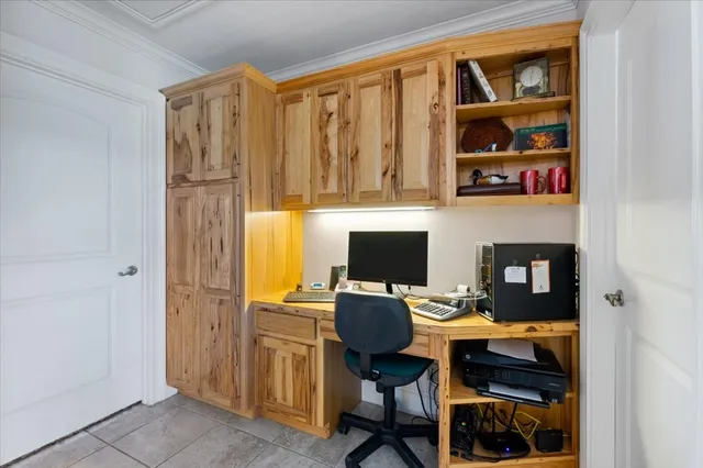 a view of a workspace with furniture and a window