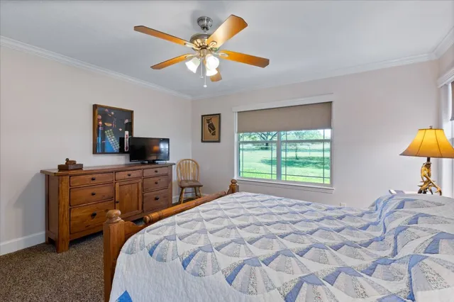 a bedroom with a large bed and a flat tv screen on dresser