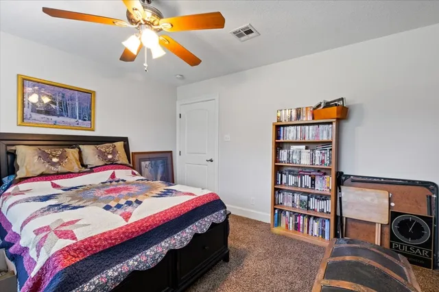 a bedroom with a bed and a book shelf