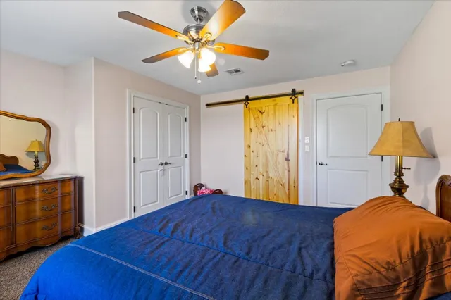 a bedroom with a bed and a lamp on dresser