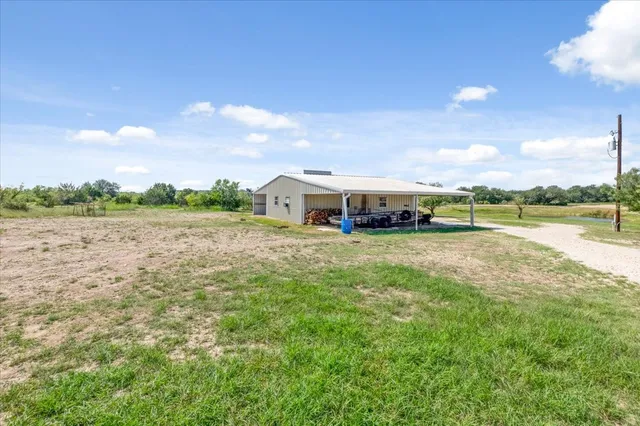 a front view of house with yard and lake in background