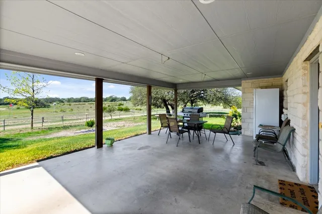a view of a porch with chairs and backyard