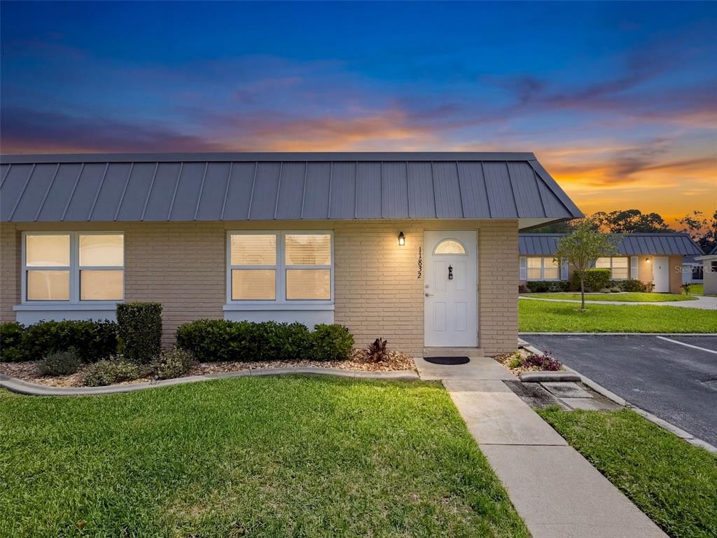 11832 Boynton Lane, Unit 24B New Port Richey, FL 34654 - Photo 1 of 42 a front view of a house with garden