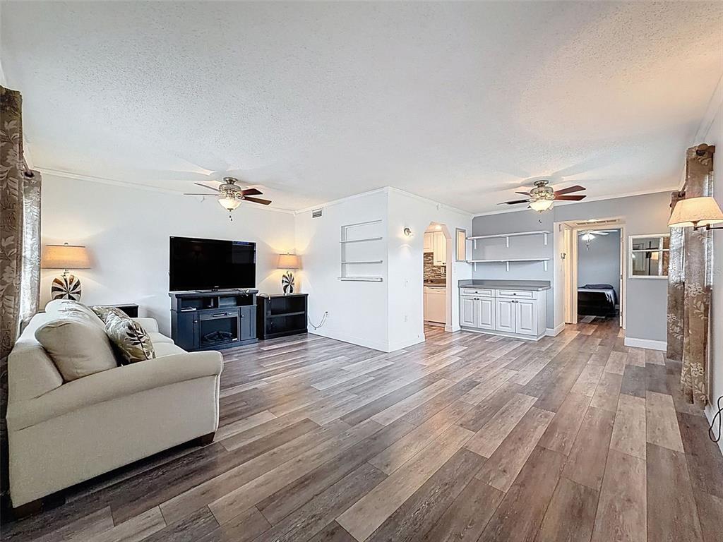 11832 Boynton Lane, Unit 24B New Port Richey, FL 34654 - Photo 2 of 42 a living room with furniture and a flat screen tv