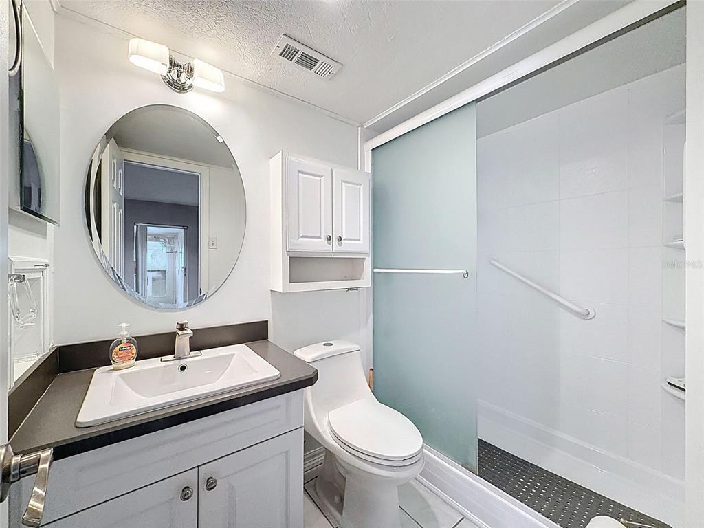 11832 Boynton Lane, Unit 24B New Port Richey, FL 34654 - Photo 24 of 42 a bathroom with a toilet a sink and mirror