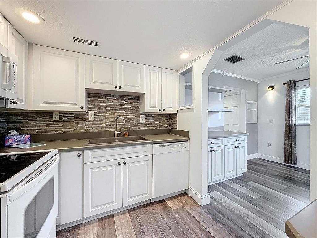 11832 Boynton Lane, Unit 24B New Port Richey, FL 34654 - Photo 3 of 42 a kitchen with sink cabinets and wooden floor