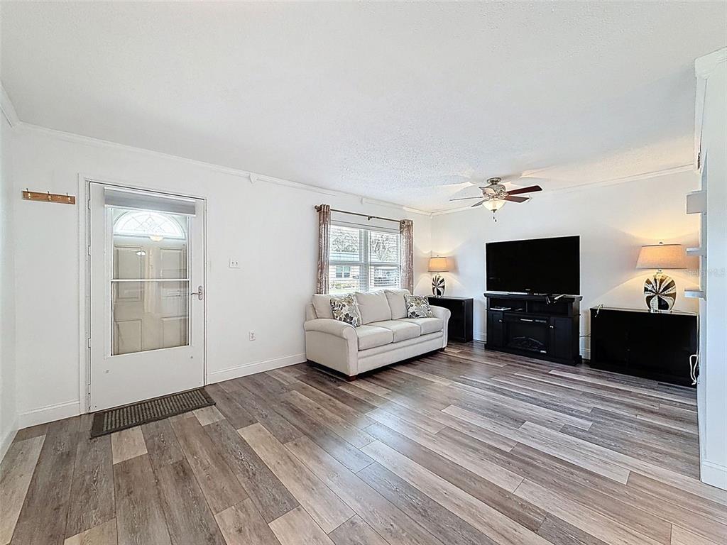 11832 Boynton Lane, Unit 24B New Port Richey, FL 34654 - Photo 5 of 42 a living room with furniture and a flat screen tv