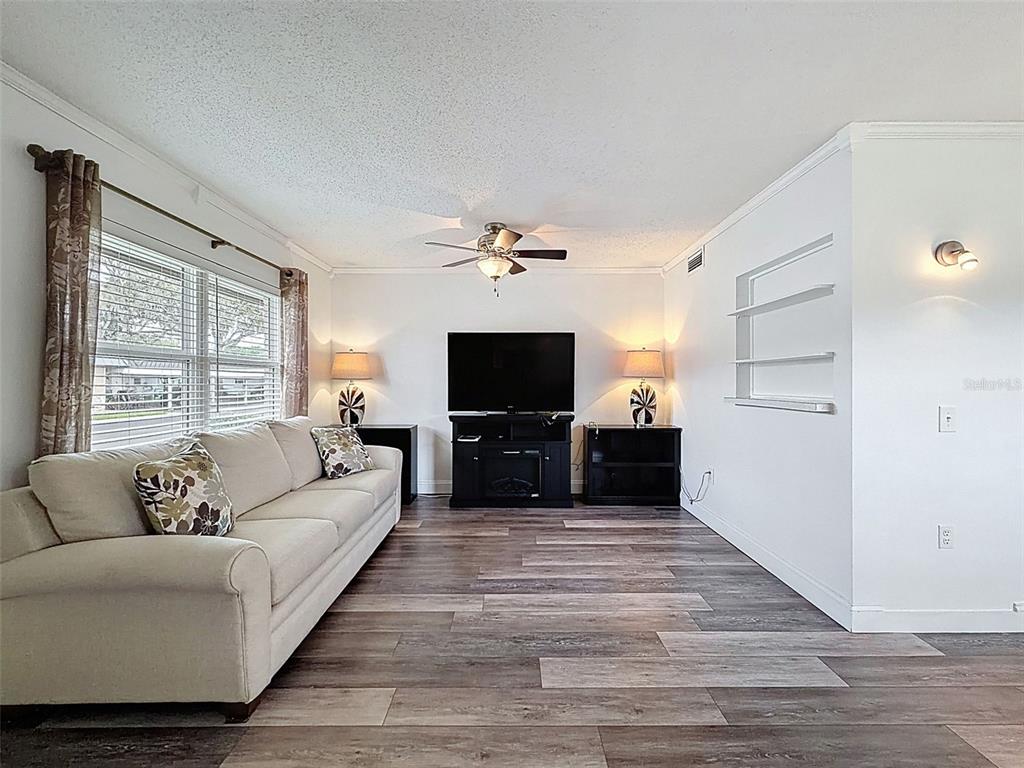 11832 Boynton Lane, Unit 24B New Port Richey, FL 34654 - Photo 6 of 42 a living room with furniture and a flat screen tv