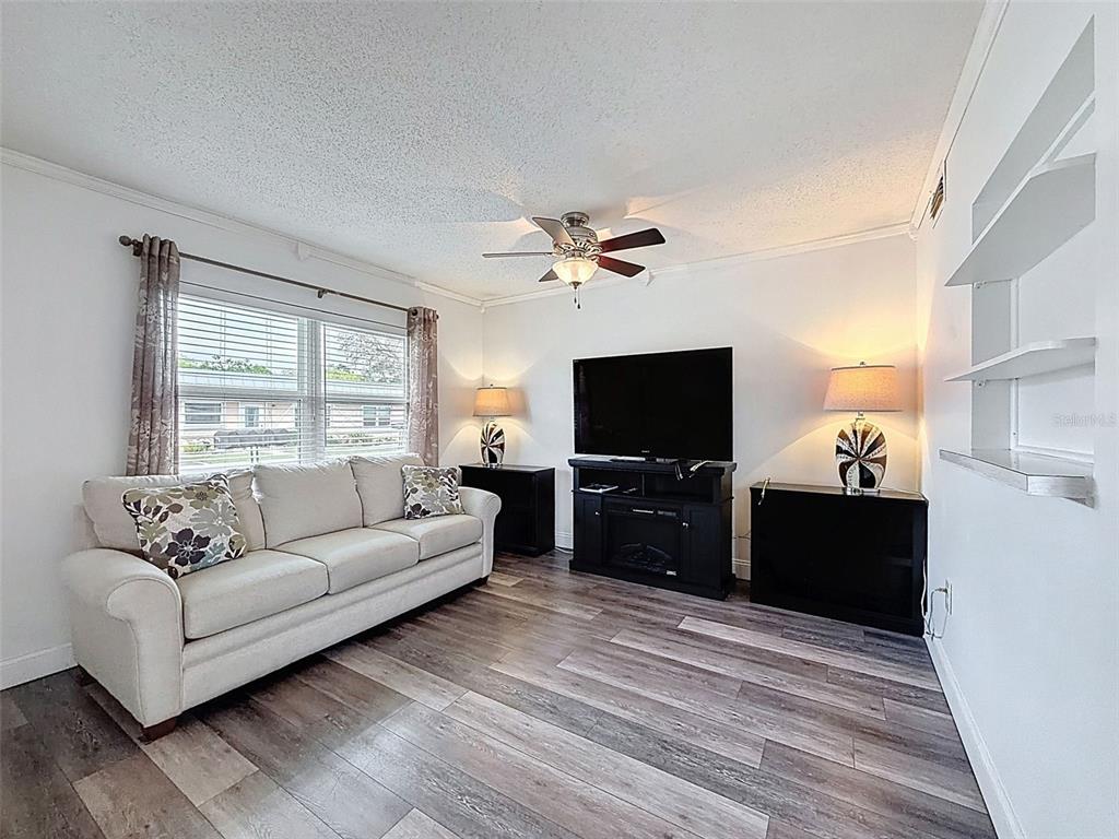 11832 Boynton Lane, Unit 24B New Port Richey, FL 34654 - Photo 7 of 42 a living room with furniture and a flat screen tv