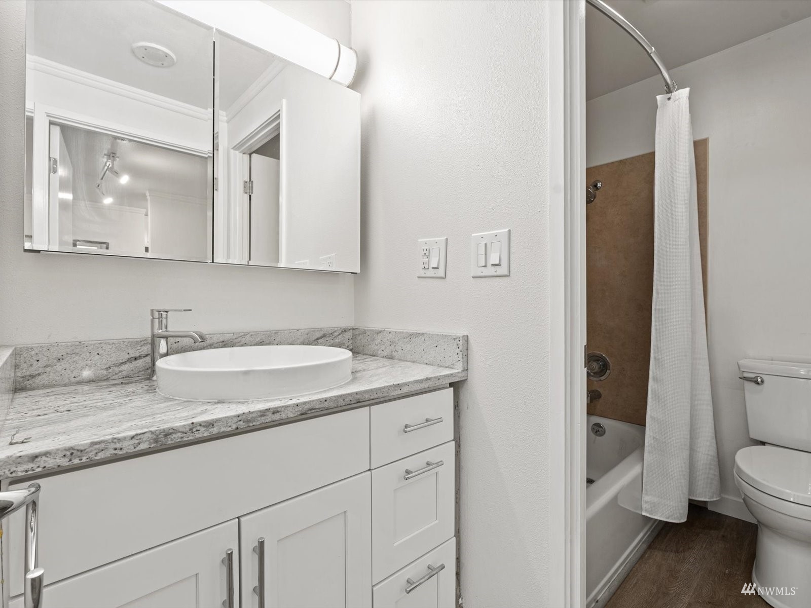 1300 University Street, Unit 2C Seattle, WA 98101 - Photo 9 of 20 a bathroom with a granite countertop sink a toilet and a mirror
