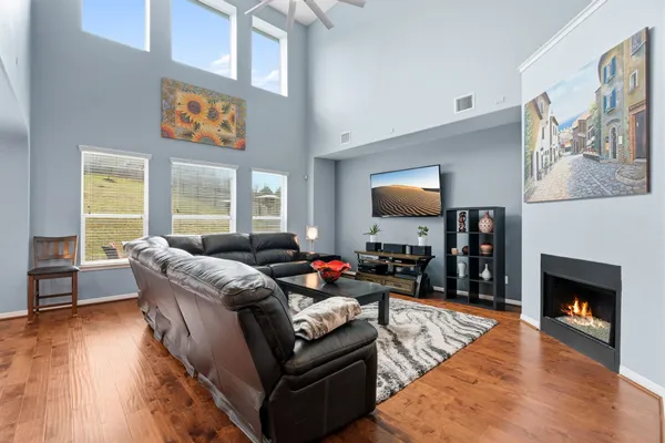 a kitchen with stainless steel appliances granite countertop a refrigerator a stove and white cabinets with wooden floor
