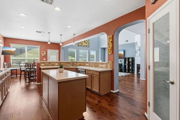 a large kitchen with cabinets and a wooden floor