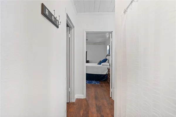 a view of a bedroom with a bed and wooden floor