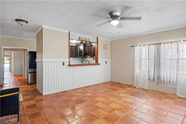 a view of an empty room with a window and a ceiling fan