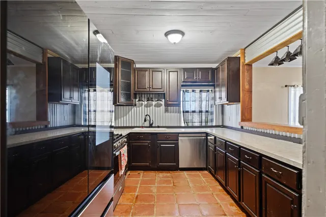 a large kitchen with stainless steel appliances granite countertop a sink stove and refrigerator