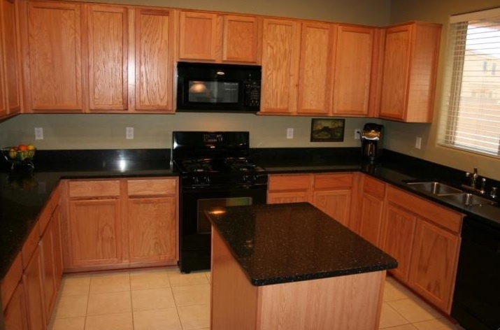 6912 West Carson Road Laveen, AZ 85339 - Photo 3 of 24 a kitchen with stainless steel appliances granite countertop a stove a sink and a microwave