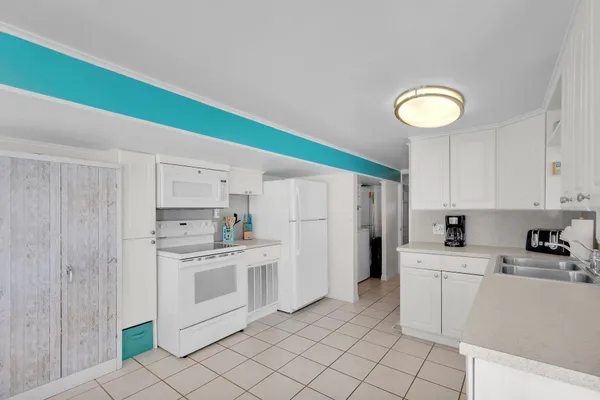 a kitchen with white cabinets and white appliances