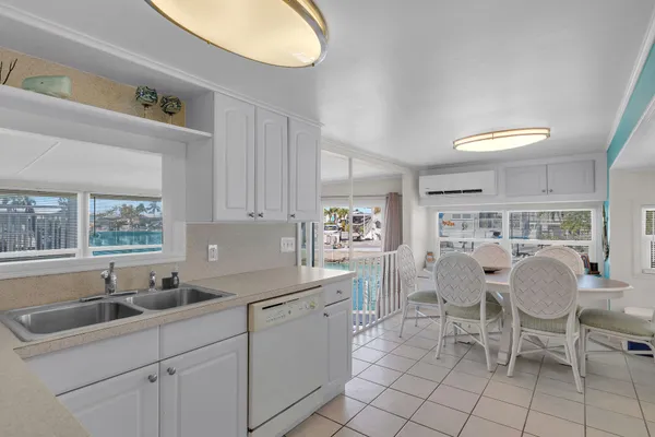 a kitchen that has a sink and chairs