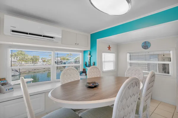 a dining room with furniture and a floor to ceiling window