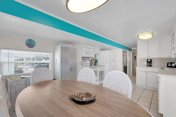 a kitchen with a table chairs and a wooden floor