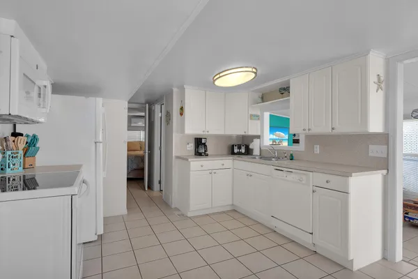 a kitchen with cabinets and chairs