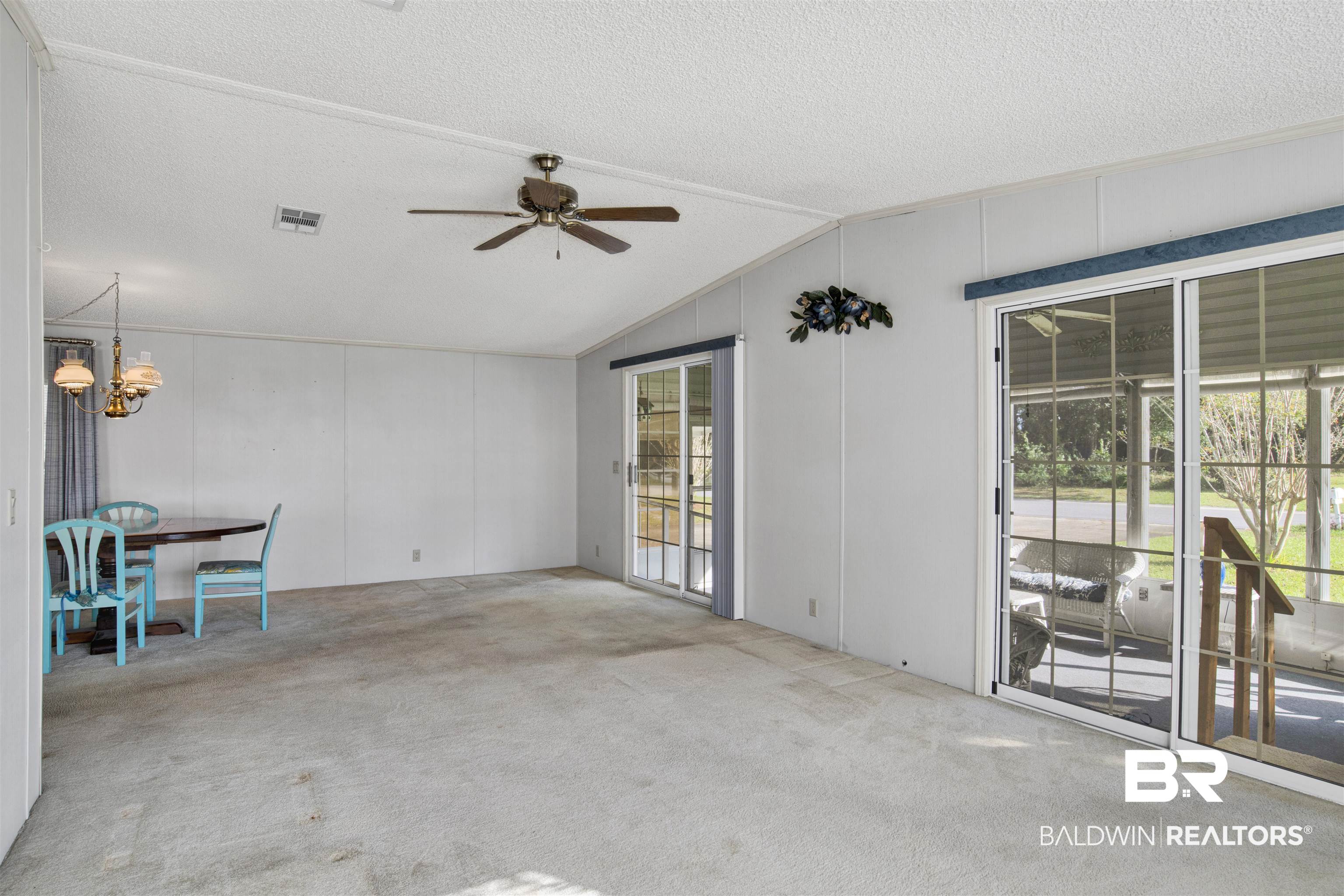 1216 Ridgewood Drive Lillian, AL 36549 - Photo 9 of 29 Unfurnished room with carpet floors, a textured ceiling, ceiling fan, a decorative wall, and lofted ceiling