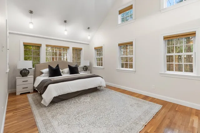 a spacious bedroom with a bed and wooden floor