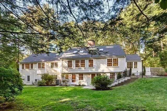 a front view of a house with a yard and trees