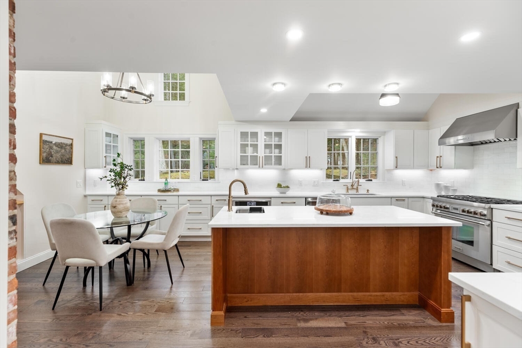 156 Cherry Brook Road Weston, MA 02493 - Photo 8 of 30 a kitchen with stainless steel appliances granite countertop a stove a sink dishwasher and a dining table with white countertops
