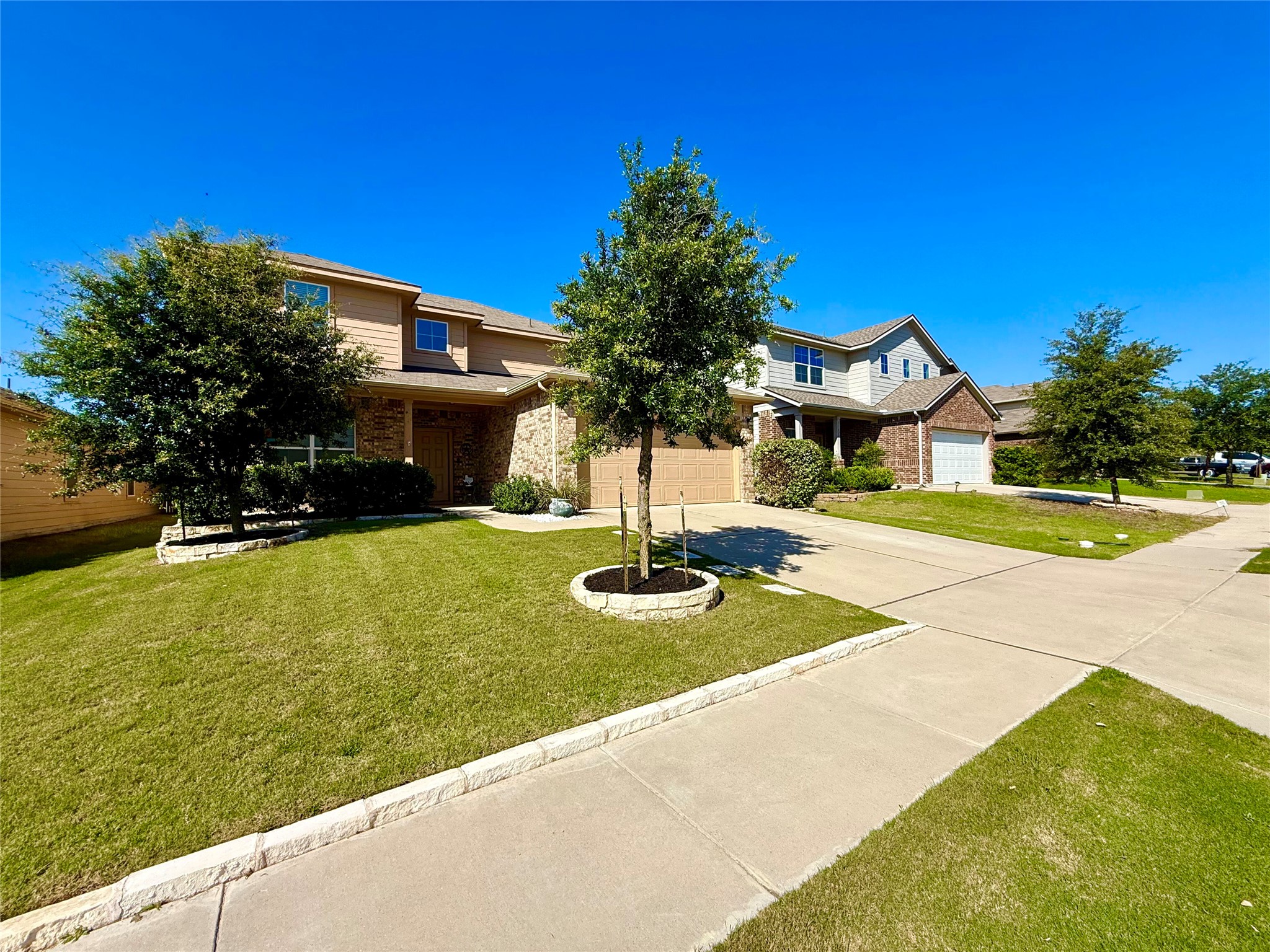 11700 Andesite Road Manor, TX 78653 - Photo 3 of 32 Street view combining brick and siding with a welcoming front yard and concrete driveway.