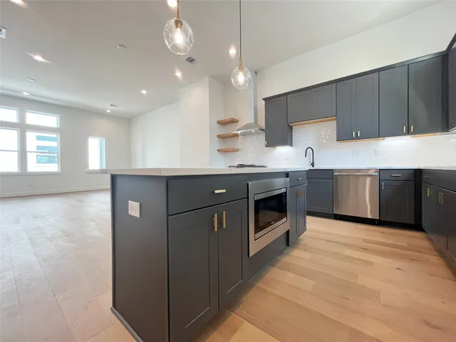 a kitchen with stainless steel appliances granite countertop a sink a stove and a refrigerator