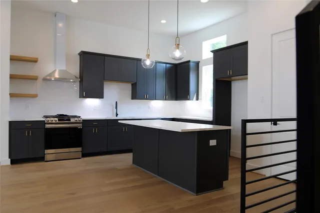 a kitchen with stainless steel appliances granite countertop a refrigerator a sink and a stove