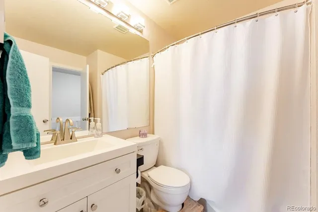 a bathroom with a sink mirror and a toilet