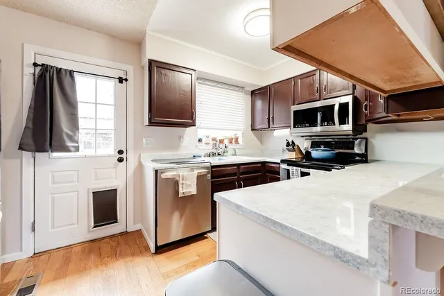 a kitchen with stainless steel appliances a stove microwave and sink