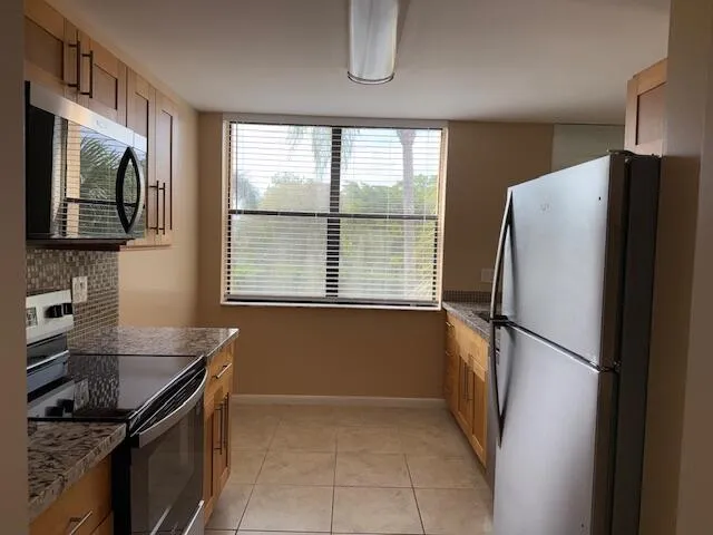 a kitchen with granite countertop a refrigerator and a sink