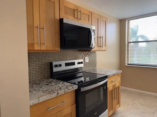 a white refrigerator freezer and a stove sitting inside of a kitchen