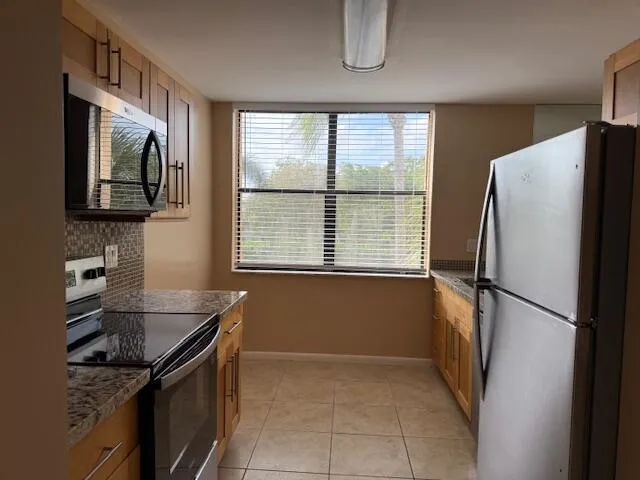 a kitchen with granite countertop a stove and a microwave