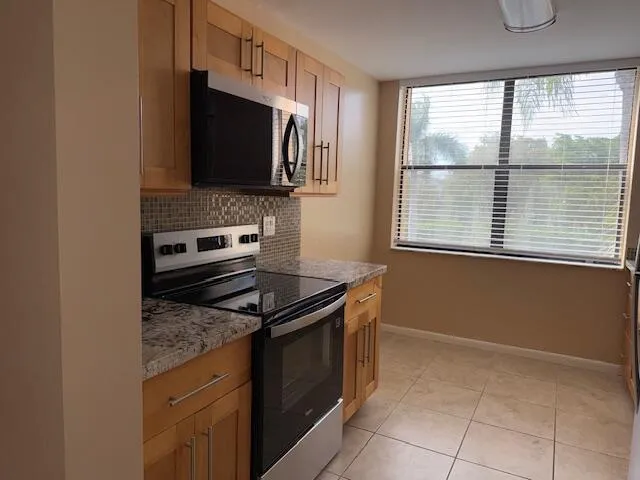a white refrigerator freezer and a stove sitting inside of a kitchen