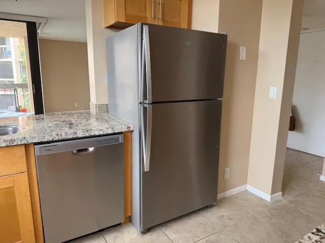 a kitchen with metallic refrigerator freezer and a dishwasher