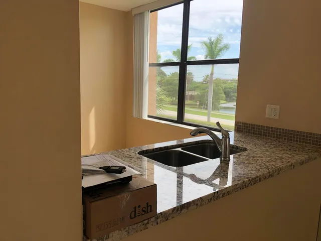 a kitchen with a sink and a stove next to a window